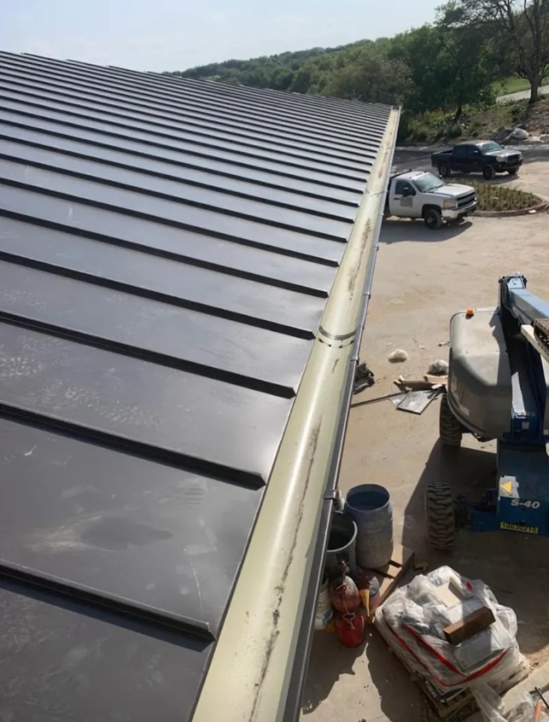 Standing seam panel and gutter detail on a metal roofing jobsite in Springfield